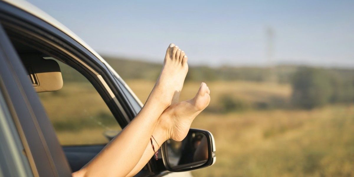 Jambes féminines qui dépassent la fenêtre d'une voiture contrôlée par Gégo Team avant de partir en vacances