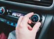 Main d'homme qui règle le bouton de climatisation de sa voiture
