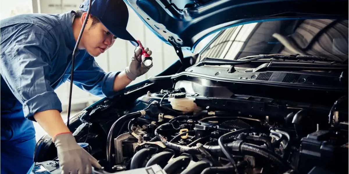 Contrôle technique d'une voiture par un mécanicien qui vérifier le moteur