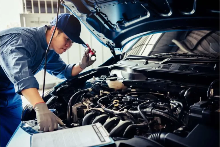 Contrôle technique d'une voiture par un mécanicien qui vérifier le moteur